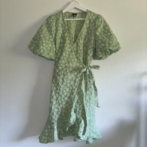 Grön Sommarklänning - Säljer denna fina sommarklänning jag endast använt vid ett tillfälle! Den har en liten fläck vid skurningen på halsen som knappt syns, i övrigt inga defekter!🤩  Den har en  anpassningsbar passform, jag skulle säga att den passar både M och L!🤗
