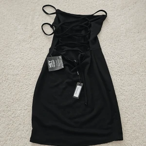 Klänning med etikett S - Oanvänd klänning med öppen rygg. Strl. S men passar för en Xs