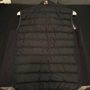 Svart Parajumper väst  - Svart parajumper väst i storlek xs. Jackan är i mycket bra skick förutom ett mindre hål som lagats av skräddare på ryggen. Perfekt för användning på hösten och våren. 