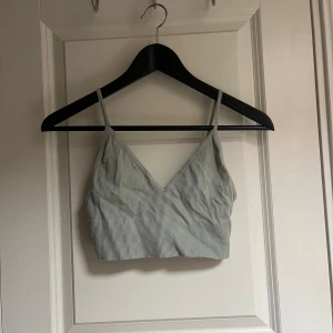 Ljusgrön topp - Snygg, mjuk och bekväm topp i en fin ljusgrön färg. Toppen har en V-ringning och tunna axelband. Den är perfekt för att bära under en tröja eller som en topp i sig själv.