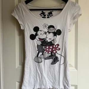 Vit t-shirt, Disney  - Söt stretchig t-shirt med motiv av Musse Pigg och Mimmi Pigg. T-shirten är vit med ett tryck framtill och baktill. Mycket mjuk och skön!