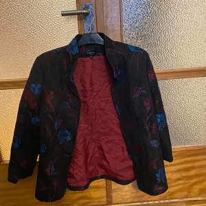 A pre owned blazer in size 42 It has flowers embroided and has like a tapestry kind of fabric!  Measurements laying flat:  Pit to pit 53cm  Length 70cm 