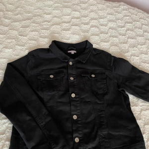 Svart Jeansjacka - Oanvänd jeansjacka. Strl L men den är aningen tajt i modellen. Stretchigt tyg