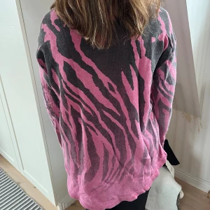 True religion sweater  - True religion i rosa och svart zebra, hålmönstrar fram. Kortare modell fram, längre bak