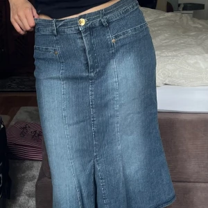 Midi jeanskjol - Midikjol i jeans köp second hand. Sitter väldigt bekvämt runt midjan och hamnar rätt lågmidjat på mig. 