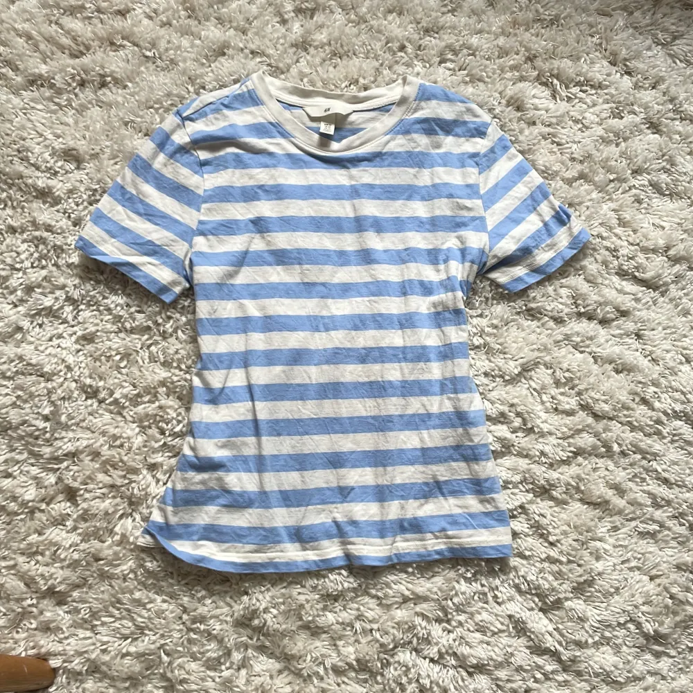 En fin t-shirt med vita och blå ränder, sitter helt perfekt men säljer då jag inte använder t-shirts så mycket❤️. T-shirts.