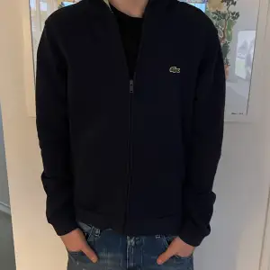 En Lacoste hoodie som jag säljer nu när den börjar bli för liten men den är som ny. Skulle säga att skicket är 10/10 