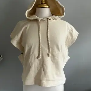En armlös hoodie som är lite croppad