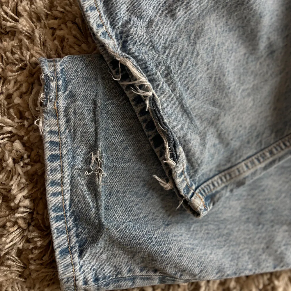 Jeans köpta från Zara i ljusblått jeanstyg. De har en sliten look och en beninnerlångd på 86 cm. Högmidjade och åtsittande upptill (32 cm i midjemått) men raka/ vida ben. Tyvärr lite slitna vid fållen då de är för långa för mig (bild 3). Storlek 34 💙. Jeans & Byxor.