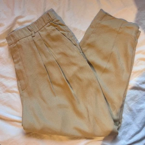 Chinosbyxor Zara - Fina Chinosbyxor från Zara i kamelfärg. Byxorna är i mycket gott skick, har endast använts en gång. Byxorna är av lätt material och ör i storlek XL.
