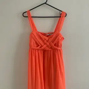 Korallfärgad klänning från Gina Tricot, modell: Mini Party Dress art. 28863. 100% polyester. Ca 85 cm från axel och ner  Rök- och djurfritt hem