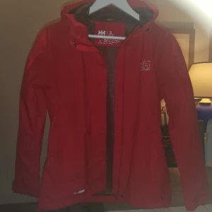 Röd Helly Hansen Jacka Regn Outdoor Dam - Tunn, röd HH regn och vind (Outdoor) jacka i storlek S. Använd 1 gång. I mycket fint skick. Har tom taggen kvar. 