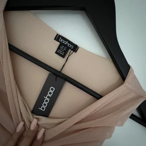 Ärmlös midiklänning i Mesh  - Elegant klänning i Mesh med rysch  från BOOHOO som är helt ny och endast testad. Färgen STONE  & Storlek 40  Ordinare pris: 576 kr Skriv för fler bilder😁