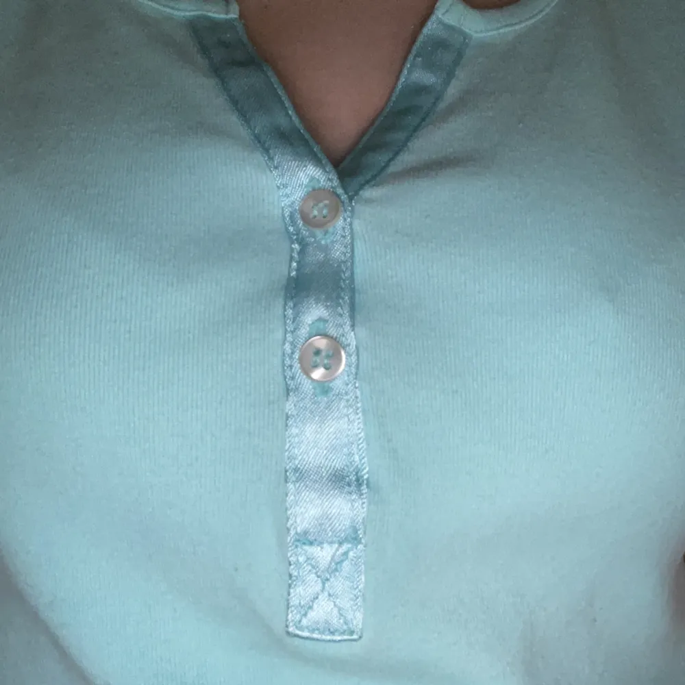 En turkos t-shirt med knappar. Den är från Kappahl och är i storlek s men passar med xs.💞💞. T-shirts.