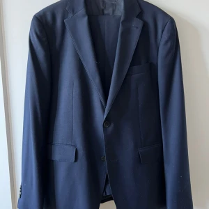 Kostym - Kavaj med tillhörande kostymbyxor. 