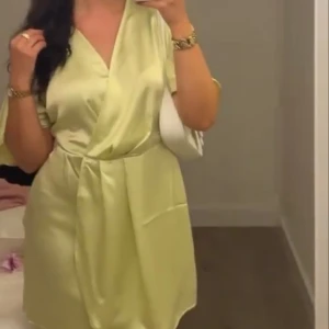 Ljusgul miniklänning - Kort ljusgul satinklänning.  Använd vid ett tillfälle, mycket bra skick. Storlek M. 