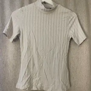 Tight beige T-shirt med kort polokrage från H&M som tyvärr aldrig kommit till användning. Strl XS, fint skick🤍