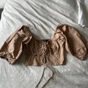 Beige topp - Puffärm och knyte fram Aldrig använd 