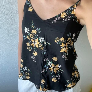 Blommig linne - Svart somrig linne med blommor. Passar perfekt till till fest🫶 