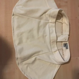 Minikjol - Kjolen är uppsydd, den är krämfärgad.