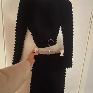 Svart set - Svart set med tröja som har öppen rygg med tillhörande kjol