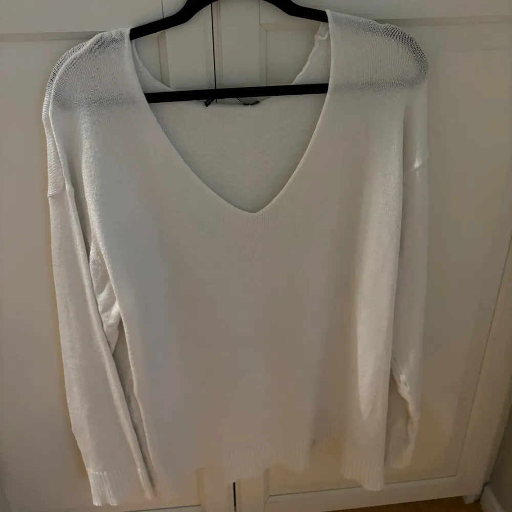 En stickad tunn v-ringad tröja. Den är väldigt skön och i en fin vit färg. Nästan helt oanvänd. Tröjor & Koftor.