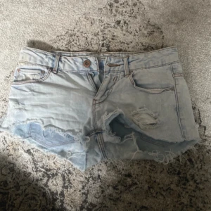 Jeansshorts  - As snygga lågmidjade jeanshorts med slitningar!  Midjemått tvärs över: 37