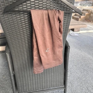 Gymshark Tights - Bruna byxor från Gymshark. Använda mycket så någon liten defekt så som någon noppra, annars fint skick.