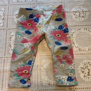 Blommiga leggings - Små grå-blommiga leggings för bebis i storlek 80. Från H&M. Aldrig använda.