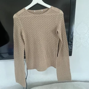 Guldig/beige glittrig tröja - Så fin guldig/beige tröja som är glittrig med utsvängda ärmar🎀 lite genomskinlig men inte jätte. Lappen är borta men skulle säga att den passar xxs-s. Den sitter fint och tajt vid midjan.