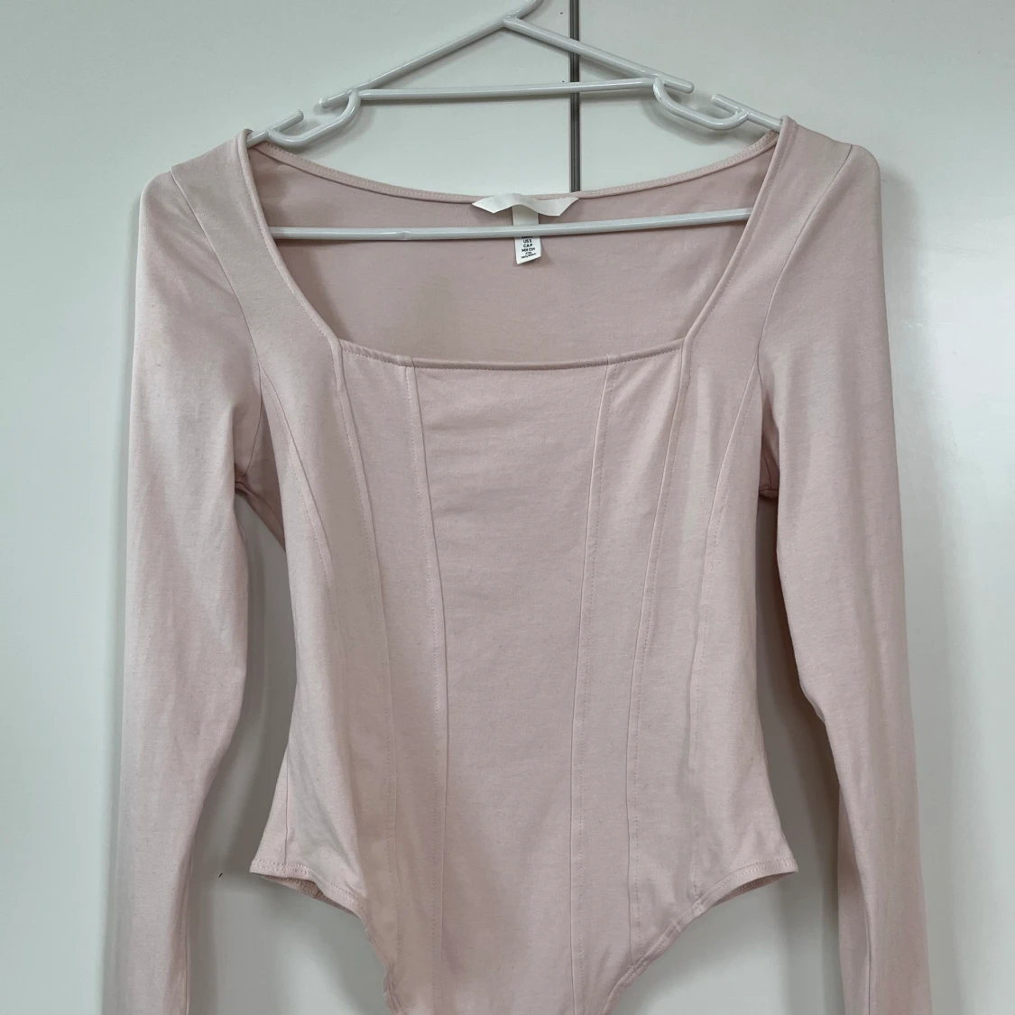 Ljusrosa body med korsettdesign och fyrkantig halsringning