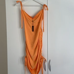 Festklänning  - Oanvänd festklänning, figurformad och går att anpassa längden med snören både vid höften och axlarna:) Passar xs/s