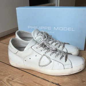 Phillipe Model Sneakers - Phillipe model sneakers - Storlek: EU43 - Färg: Vit – OG: box + dustbag - OBS: Skorna är lite slitna och vänstra skon har gått sönder lite vid sulan!! Tveka inte på att - skriva vid frågor eller funderingar. 