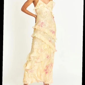 Volangklänning - Lång klänning med söta volanger, ej använd och i orginalförpackning.   Obs den är smal över höfterna 