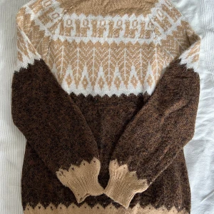 Stickad tröja, strl M - Stickad tröja i alpacka. Tunn och värmande, med fint mönster. Säljes då den inte kommer till användning. Mått: bredd 47 cm, längd: 66 cm. Mät en tröja du har hemma för att få en uppfattning om passformen💗💗 Handstickad