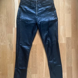 PU LEATHER svarta läder skinn vaxade byxor från H&M - Vaxade byxor med dragkedja framtill. Storlek 28. Passar en S eller liten M. Väldigt fint skick.