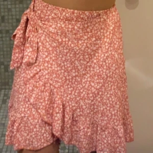Blommig kjol - Persikofärgad blommig kjol💐Går att knyta och justera lätt själv. Använd 1 gång perfekt för sommaren!☀️ Strl 36  65kr+ frakt🫶🏻