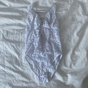 Spets body - Vit body av spets med kryss detaljer i ryggen, knäppa med knappar i skrevet. Står ingen storlek på den men passar mig som har xs. 130 kr med frakt inkluderat i priset. 