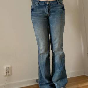 Ett par lågmidjade, utsvängda jeans från kangol 😊  Mått:  Midjemått: 37 cm  Innerbenslängd: 79 cm Total längd: 100 cm  Benvidd längst ner: 23 cm, jag är 165 cm💞