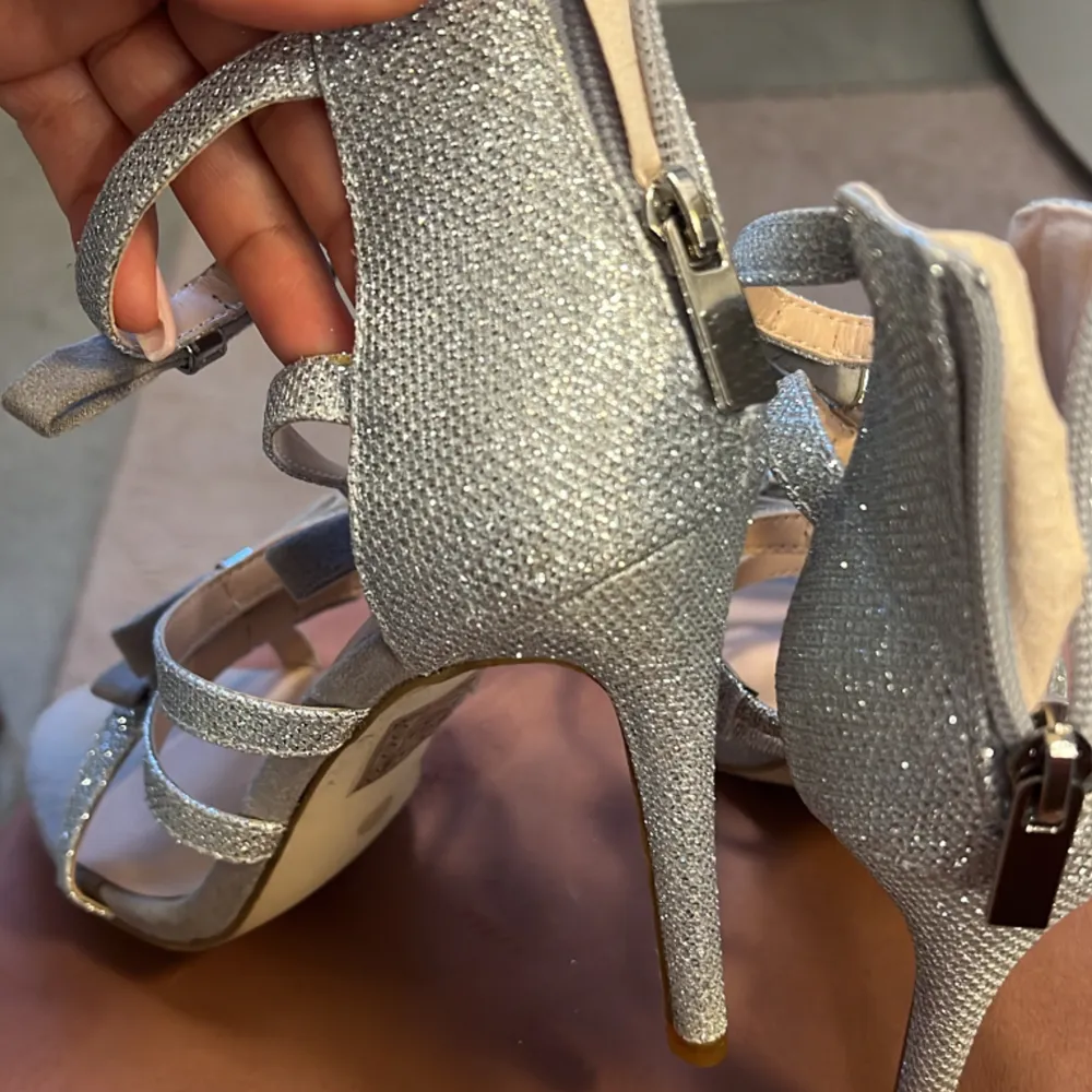  Silver glittriga klack skor med små rosetter helt ok skick använda fåtal gånger. Skor.
