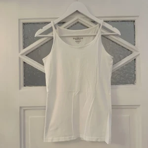 Vitt linne från Newbody - Vitt linne från Newbody som aldrig använts. Bra kvalité på tyget, inte tunt. 95% bomull