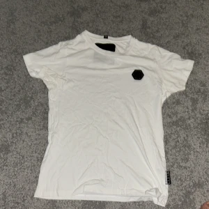 Philipp Plein t-shirt  - Philipp Plein t-shirt med QR kod, har haft den i garderoben länge. Den har små små hål nära badgen. Därför har jag lagt den på 200 kr ( har alltså sänkt när priset jätte mycket eftersom hålen).