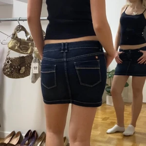 Mörkblå jeanskjol - Mörkblå jeanskjol med så snygga men diskreta detaljer!! Midjemått 38 cm, längd 32 cm. Den är från en barnkollektion så det står L på lappen men skulle säga att den helt klart passar en strl XS/S då den har lite stretch.🖤