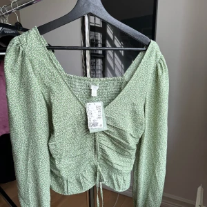 Blommig blus  - Grön blommig bli från hm som aldrig är använd.