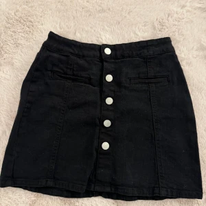 Svart jeanskjol  - Säljer nu denna fina svarta jeanskjol då jag knappt använt den. Bra skick, storlek 146/152 men går även att använda ifall man bär en storlek större, köpt i Lindex för ett tag sedan och säljer nu för 50 kr. 