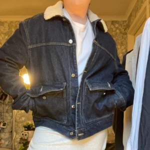  En fin jacka i jeans tyg med vitt fluffigt krage och två tydliga fickor fram på  Nästan oanvänd