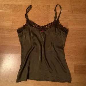 Linne/camisole🪴 - Grönt linne med spets kring urringningen🍂i siden med justerbara axelband! Det är bara skriva om man har frågor eller vill ha fler bilder!!