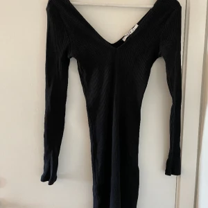 Svart klänning  - Svart miniklänning från NA-KD. V-ringad fram och bak. Ribbad Aldrig använd!