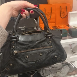 Balenciaga väska - Intressekoll!! På min super fina balenciaga city bag som är köpt för 8000 på vestarie och är äktahetskontrolerad och tillkommer bag, säljer endast för bra pris så går inte ner!