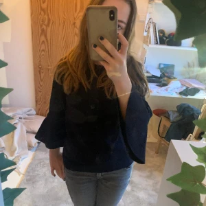 Mörkblå blus från howtokissafrog  - Blus från howtokissafrog. Storlek 8år eller 134 ungefär. Säljer den eftersom den är för liten som man kan se på bilden. Den var som en trekvartsärm på mig men egentligen är den lite liten för mig. Annars trekvartsärm om man  vill